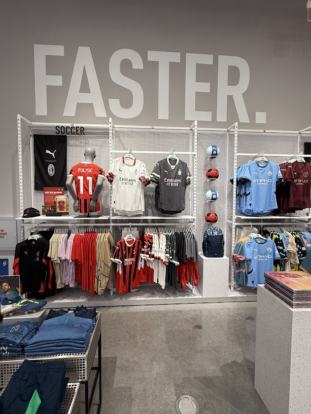 An images of soccer Emirates and Etihad sports jerseys and balls against a gray wall with the words "Faster." on it
